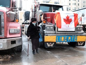 A woman tries to navigate a downtown Ottawa street as hundreds of truck drivers remain parked in the parliamentary precinct.