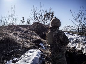 A Ukrainian service member stands in a trench at his unit's position at the contact line near the village of Svitlodarsk in Donestsk region on Feb. 13.