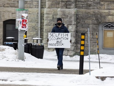 Anti-vaccine mandate protests continue in downtown Ottawa. A lone counter protestor crosses Elgin Street. Saturday, Feb. 12, 2022.