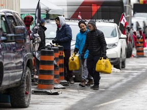 Gas cans are ferried into the Red Zone near Parliament Hill on Wednesday.