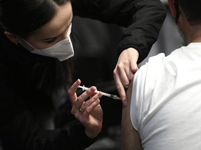 Second-year medical student Nina Hadzimustafic delivers a COVID-19 booster shots at Jabapalooza, a pop up vaccine clinic, in Ottawa, on Monday, Dec. 20, 2021. Another Jabapalooza was set for TD Place on Feb. 18. THE CANADIAN PRESS/Justin Tang