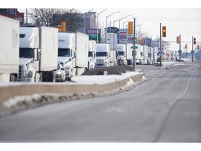 A line of trucks waits along the road to the Ambassador Bridge border crossing in Windsor, after protesters blocked the road Monday night.