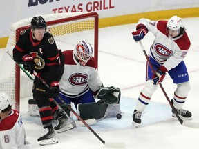 Ottawa Senators left wing Brady Tkachuk (7) tries to find the puck in front of Montreal Canadiens goaltender Andrew Hammond (37) and defenceman Alexander Romanov (27) during third period NHL hockey action in Ottawa, on Saturday, Feb. 26, 2022.