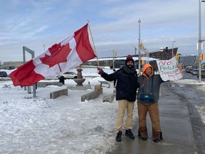 Maninder Singh and Matt Wellman, two holdout protestors at the Sir John A MacDonald Parkway and Booth Street on Monday, Feb. 21, 2022.