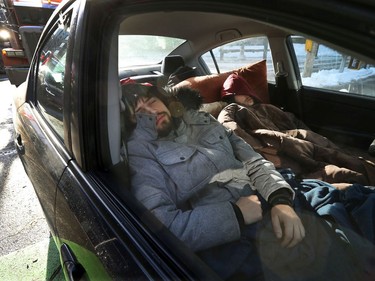 OTTAWA - Feb 1, 2022 - Anti vaccine mandate protesters and truckers protesting their fifth day in downtown Ottawa Tuesday. Protesters James Brien and Gabriel Poisson, from Quebec, get some sleep in their car early Tuesday morning in Ottawa.   TONY CALDWELL, Postmedia.