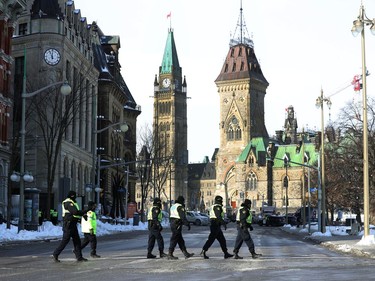 OTTAWA - Feb 1, 2022 - Anti vaccine mandate protesters and truckers protesting their fifth day in downtown Ottawa Tuesday. Ottawa Police walking toward Parliament Hill Tuesday.