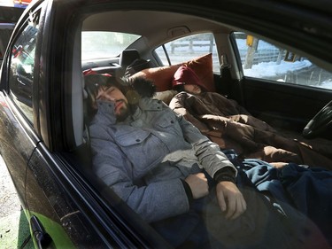 OTTAWA - Feb 1, 2022 - Anti vaccine mandate protesters and truckers protesting their fifth day in downtown Ottawa Tuesday. Protesters James Brien and Gabriel Poisson, from Quebec, get some sleep in their car early Tuesday morning in Ottawa.