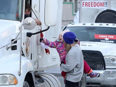 OTTAWA - Feb 1, 2022 - Anti vaccine mandate protesters and truckers protesting their fifth day in downtown Ottawa Tuesday. A little girl gets a chance to pull the horn of a large truck on Wellington Street Tuesday.
