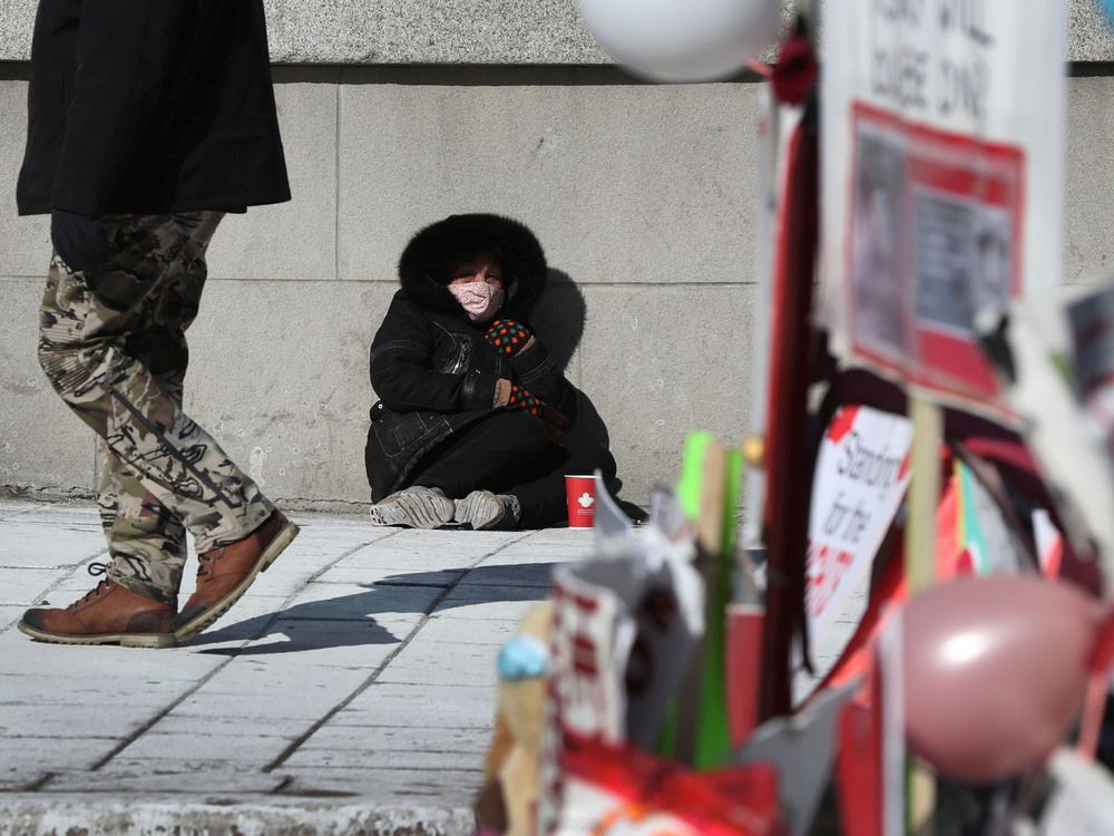 Truckers occupation and protesting continues its 18th day in downtown Ottawa, Monday afternoon. A panhandler on Rideau Street.