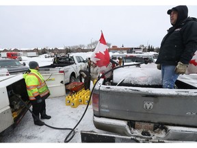 Protesters and truckers gather at RCGT Park to get some gas Thursday, the seventh day of the downtown demonstration. RCGT Park has gas, bathrooms, and a place to get warm.