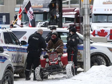 Anti-vaccine mandate protesters and truckers protesting their eighth day in Ottawa Friday. A man with a  4 wheeler gets asked questions by the Ottawa Police on Kent Street in Ottawa.