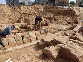 Men work in a newly discovered Roman cemetery in Gaza, in this handout photo obtained by Reuters, February 17, 2022.