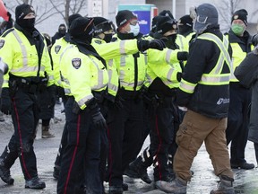 Ottawa police remove an anti-mandate protester from among the counter-protest crowd on Saturday, Feb. 5, 2022.