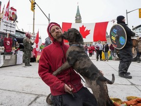 File: A protester gets a kiss from their dog as they sit on Wellington Street in front of Parliament Hill. Ottawa Humane Society Bruce Roney said that, despite widespread misinformation, the agency would never 'euthanize a pet out of spite.' euthanize a pet 'out of spite.'