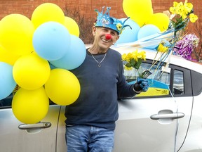 Joe Silverman outside his Old Ottawa South home, alongside his car decorated with Ukraine-themed decorations.