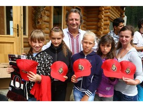 Ottawa Senators owner Eugene Melnyk hands out swag to children at a life skills camp in Ukraine. Melnyk donated millions in his nearly 30-year involvement with Help Us Help, a charity for orphans and children in Ukraine. Photo: Adriana Luhovy / Help us Help charity