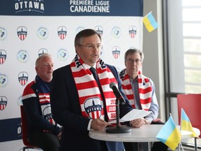Jeff Hunt (left), President and Strategic Partner of Atlético Ottawa, Andrii Bukvych, Chargé d'Affaires at the Ukrainian Embassy (middle) and Jim Watson (right) announce an initiative in support of humanitarian aid for Ukraine in Ottawa, March 28, 2022.