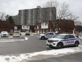 Ottawa Police Service vehicles sit parked on Monday near the townhouse where the body of Marie Gabriel was found.