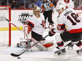 Tim Stutzle (18) clears the puck from the side of the net as goaltender Anton Forsberg (31) of the Ottawa Senators looks on in the first period against the Florida Panthers at the FLA Live Arena on March 3, 2022 in Sunrise, Florida.