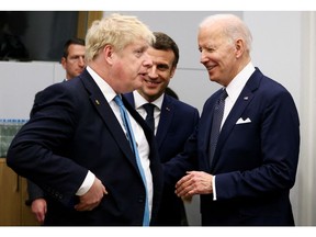 British Prime Minister Boris Johnson speaks with U.S. President Joe Biden and France's President Emmanuel Macron before a G7 leaders meeting during a NATO summit March 24 on Russia's invasion of Ukraine.