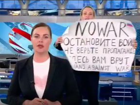 An anti-war protestor interrupts a Russian-state TV broadcast with a sign that reads in English and Russian: “NO WAR. Stop the war. Don’t believe propaganda. They are lying to you here.”