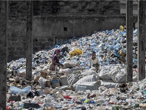 Waste pickers gather plastic bottle waste at the Dandora garbage dump where people scavenge through the landfill for re-usables and recyclables that can be re-sold in Nairobi on February 26, 2022