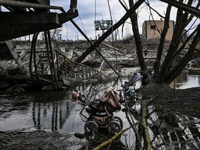 Abandoned strollers are pictured under a destroyed bridge as people flee the city of Irpin, west of Kyiv.