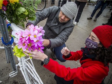 A group of people gathered at the corner of North River Road and Donald Street, where a cyclist was struck and killed last week. The group, led by Bike Ottawa, installed a ghost bike at the corner to pay tribute to the woman whose  life was lost. Dave Robertson and Barbara Greenberg, board members with Bike Ottawa, placed flowers on the ghost bike Sunday, March 20, 2022.