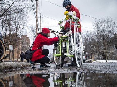 A group of people gathered at the corner of North River Road and Donald Street, where a cyclist was struck and killed last week. The group, led by Bike Ottawa, installed a ghost bike at the corner to pay tribute to the woman whose  life was lost. Barbara Greenberg, a member of the board of Bike Ottawa, arrived on a bike, towing the ghost bike for the ceremony Sunday, March 20, 2022.