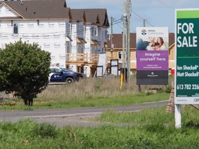 Real estate signs stand in front of new homes being constructed in Ottawa, Ontario, Canada, May 27, 2021. REUTERS/Patrick Doyle