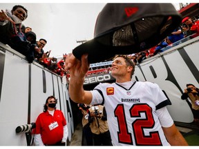 FILE PHOTO: Jan 16, 2022; Tampa, Florida, USA; Tampa Bay Buccaneers quarterback Tom Brady (12) hands his hat to a fan after beating the Philadelphia Eagles 31-15 in a NFC Wild Card playoff football game at Raymond James Stadium.