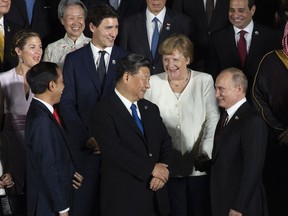 Prime Minister Justin Trudeau, then-German Chancellor Angela Merkel and Chinese President Xi Jinping share a moment with Russian President Vladimir Putin at the G20 Summit in Osaka, Japan in 2019.