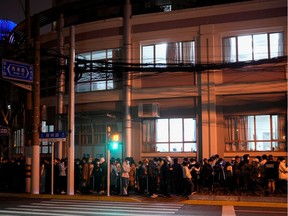 People line up near a nucleic acid testing site outside a hospital during mass testing for the coronavirus disease (COVID-19) amid the COVID-19 pandemic, in Shanghai, China March 27, 2022.