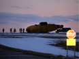 Emergency crews work around the wreckage of a downed CH-149 Cormorant search and rescue helicopter at 9 Wing Canadian Forces Base Gander, in Gander, N.L., Thursday, March 10, 2022.