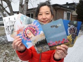 Emily Chen holds some of the postcards that her group of 16 artists are selling to raise money for Ukraine.