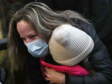 Tamara Lich (mask) hugs a little girl after leaving the Ottawa Courthouse in Ottawa Monday.  Convoy protest organizer Lich was released on bail Monday afternoon.