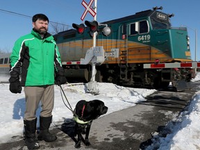 OTTAWA - March 8, 2022 - Stacy Bleeks, who is visually impaired and has a guide dog, stands near the railway crossing on Jockvale Road in Ottawa Tuesday. He is among several people in this area who are concerned about a sidewalk/multi-use path that crosses the VIA tracks.