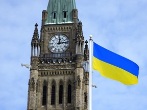 The flag of Ukraine is seen alongside the Peace Tower in Ottawa recently.