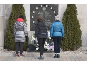 Three women contemplate the commemorative plaque on the wall of Polytechnique in Montreal, where 14 women were murdered in an anti-feminist attack at Ecole Polytechnique on December 6, 1989.