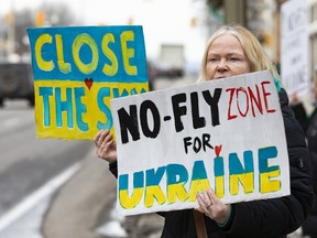 Ein Demonstrant gegenüber der US-Botschaft am Sussex Drive fordert die NATO auf, mehr zu tun, um die russische Invasion in der Ukraine zu beenden.