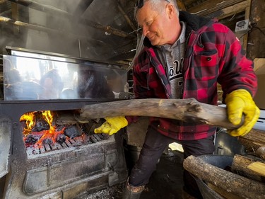 OTTAWA -- Since 1920 the Proulx family have operated their sugar bush in Cumberland. Francois Proulx stokes the fire of the sap boiler on Wednesday, Mar. 16, 2022