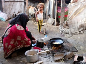 A woman cooks at a makeshift camp for internally displaced people (IDPs) in Aden, Yemen on March 15, 2022.