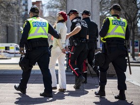 A person is taken into custody by police during the 'Rolling Thunder Ottawa' rally in the downtown core on Saturday.