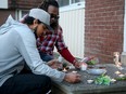 About 20 people gathered in front of Marie Gabriel's home on Friday night to remember the young mother of two who was found dead there on March 28. Her brother, David Gabriel|, left, and boyfriend Jean Hilaire Isralon were among those who lit candles.