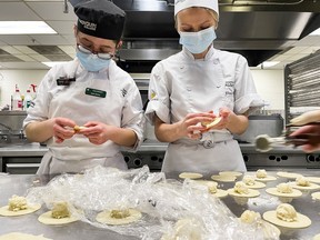 Aylin Ilkmen, left, and Ukrainian-born pastry chef Elina Olefirenko make perogies at Algonquin College as part of Tuesday's fundraiser,