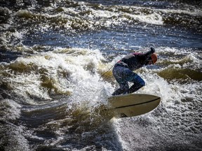 GATINEAU -- Surf's up! Water enthusiasts, including Trevor Cunningham, were enjoying the sunshine in their neoprene as they safely surfed the Ottawa River's Sewer Wave, Saturday April 2, 2022.