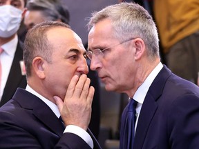 Turkish Foreign Minister Mevlut Cavusoglu (left) and NATO Secretary General Jens Stoltenberg speak at the start of the North Atlantic Council roundtable of NATO Foreign Ministers at the NATO headquarters in Brussels on April 7, 2022.
