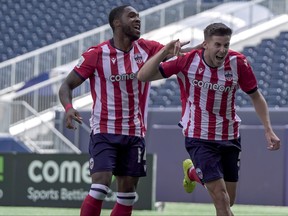 Atletico Ottawa players celebrate a goal last season.