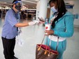 An airport worker at Los Angeles airport hands out a mask to a traveller during the COVID-19 pandemic.