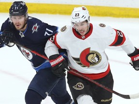 Winnipeg Jets forward Evgeny Svechnikov (left) gets tangled up with Ottawa Senators defenceman Travis Hamonic of St. Malo, Man., in Winnipeg on Thurs., March 24, 2022.